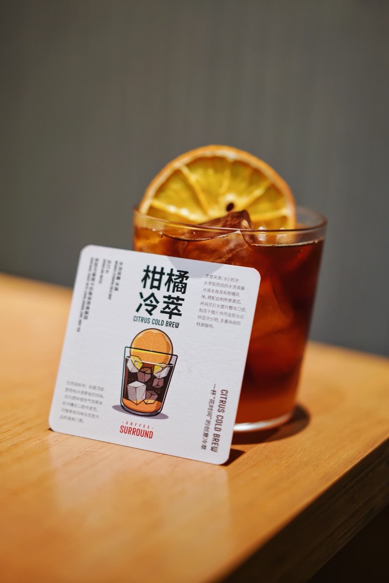 Zitrus-Cold-Brew mit einer Karte der Marke Coffee Surround