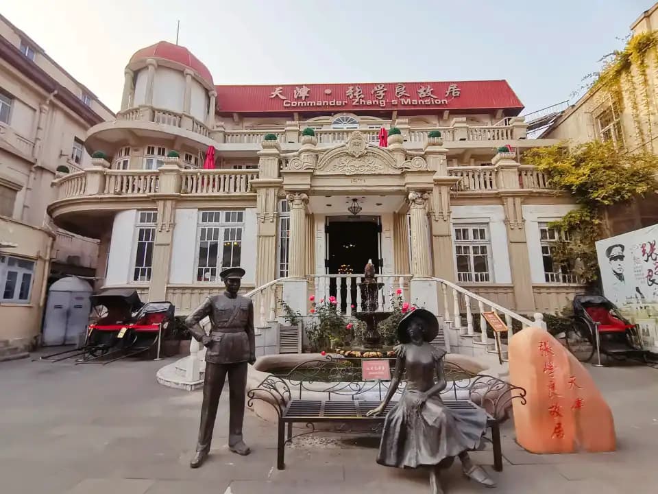 Zhang Xueliangs Wohnhaus in Tianjin mit heller Balkonfassade und Figuren im Innenhof